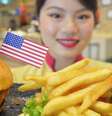 Garçonete de restaurante em Cingapura mostra hambúrguer especial criado por ocasião do encontro Kim-Trump   Foto: DW / Deutsche Welle