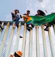 Com faixa que diz "diversidade sem fronteiras", cidadãos da América Central protestam em cerca entre EUA e México  Foto: DW / Deutsche Welle