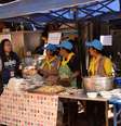 Voluntários e funcionários da cozinha real tailandesa preparam refeições para todos no acampamento da operação de resgate  Foto: BBC News Brasil