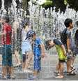 Crianças brincam na água graças às ondas de calor que trouxeram temperaturas superiores a 41.1º C, no Japão.  Foto: ANSA / Ansa - Brasil