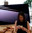 Mulher verifica seu telefone em uma  loja da Apple em shopping center de Bancoc 9/11/ 2018. REUTERS/Soe Zeya Tun   Foto: Reuters