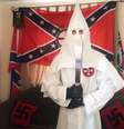 Thomas segura um facão vestido com o traje característico da Ku Klux Klan  Foto: W MIDS CTU / BBC News Brasil