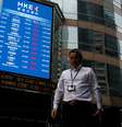 Pessoas caminham em frente a painel com informação de índices asiáticos em Hong Kong
11/10/2018
REUTERS/Bobby Yip  Foto: Reuters