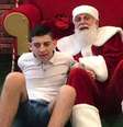 O Papai Noel João Prim ao lado do jovem Vitor.  Foto: Facebook / @jussania.maiconn / Estadão