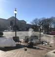 Morador de rua se protege do frio próximo à saída de ar de bueiros, na Avenida Pensilvânia, a 1 quilômetro do Capitólio, em Washington  Foto: Beatriz Bulla / Estadão Conteúdo