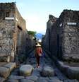 Turista caminha ao longo de uma antiga rua de paralelepípedos romanos em Pompéia, Património Mundial da UNESCO  Foto: Alessandro Bianchi / Reuters