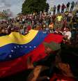 Manifestantes seguram bandeira da Venezuela durante protesto favorável ao governo na fronteira entre o país e o Brasil
24/02/2019 REUTERS/Bruno Kelly  Foto: Reuters