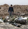 Homem caminha em meio aos destroços do avião da Ethiopian Airlines  Foto: Baz Ratner / Reuters
