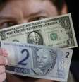 Homem segura notas de 1 dólar e 2 reais
13/12/2001
REUTERS/Gregg Newton  Foto: Reuters