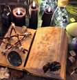 Antigo livro de bruxa com pentagrama, velas pretas, cristais e objetos rituais   Foto: iStock