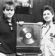 A dupla sertaneja Chitãozinho e Xororó posa ao lado do disco de diamante conquistado pela venda de 1,5 milhão do disco "Meu Disfarce", de 1987, no escritório da dupla, em São Paulo  Foto: SILVIO RICARDO RIBEIRO / Estadão Conteúdo