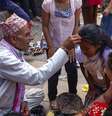 Profeta Nepal e mulheres vestidas roupas tradicionais vermelha no evento religioso no templo  Foto: iStock