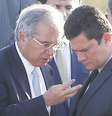 Os ministros da Economia, Paulo Guedes, e da Justiça e Segurança Pública, Sergio Moro, conversam durante cerimônia de hasteamento da bandeira nacional em frente ao Palácio da Alvorada  Foto: DIDA SAMPAIO / Estadão Conteúdo