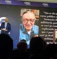 Eduardo Bolsonaro fala no palco, com imagem e frase de Olavo de Carvalho na tela atrás; em primeira edição de evento conservador no Brasil, o deputado foi ovacionado pela plateia  Foto: Ligia Guimarães/BBC / BBC News Brasil