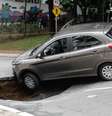 Um veículo caiu no buraco que se abriu após o asfalto ceder na Rua Carlos Comenale, no bairro da Bela Vista.  Foto: Fábio Vieira / Foto Rua / Estadão