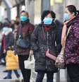 Mulheres esperam ônibus em frente ao Mercado de Frutos do Mar de Huanan, em Wuhan, onde teria começado a epidemia do novo coronavírus  Foto: EPA / Ansa - Brasil