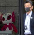 Homem usa máscara ao passar por mascotes da Olimpíada e Paralimpíada de Tóquio. REUTERS/Athit Perawongmetha  Foto: Reuters