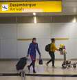 Passageira e tripulante desembarcam usando máscara no Terminal 3 do Aeroporto internacional de Guarulhos, na Grande São Paulo, em meio à epidemia do novo coronavírus.   Foto: Estadão Conteúdo