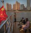 Pessoas usando máscara no rio Yangtze, em Wuhan, na China  Foto: EPA / Ansa