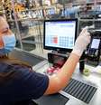 Uma mulher, que trabalha como caixa em um supermercado, limpa os instrumentos de trabalho em Bad Honnef, nas proximidades de Bonn, na Alemanha. 27/04/2020. REUTERS/ Wolfgang Rattay.   Foto: Reuters