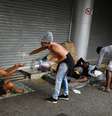 Voluntária despeja álcool gel na mão de homem durante ação de entrega de comida para pessoas em situação de rua no Rio de Janeiro
11/04/2020
REUTERS/Lucas Landau  Foto: Reuters