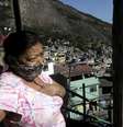 Uma mulher usa máscara protetora fica do lado de fora de sua casa, na favela da Rocinha, durante o surto de doença por coronavírus (COVID-19), no Rio de Janeiro  Foto: Ricardo Moraes / Reuters