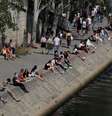Pessoas se setnam nas margens do Rio Sena, na França, após o país gradualmente relaxar medidas de confinamento pelo coronavírus. 17/5/2020. REUTERS/Gonzalo Fuentes  Foto: Reuters