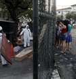 Funcionários do serviço funerário, usando roupas de proteção, recolhem o corpo de uma pessoa que morreu por problemas respiratórios em meio à pandemia do coronavírus, no Rio de Janeiro. 17/5/2020. REUTERS/Ricardo Moraes  Foto: Reuters