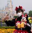 Visitante de parque da Disney tira selfie usando máscara de proteção. 11/5/2020. REUTERS/Aly Song       Foto: Reuters