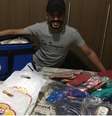 Carlos Antônio ajuda a mulher na venda de roupas femininas de criança   Foto: Arquivo Pessoal