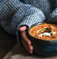 Mãos femininas segurando uma tigela de sopa de abóbora  Foto: Shutterstock / Alto Astral