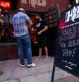 Um funcionário de um bar até então reaberto no Estado do Texas higieniza a mão de clientes. 22/05/2020. REUTERS/Nuri Vallbona. 

  Foto: Reuters