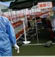 Funcionário de saúde em centro de testagem de covid-19 em Pequim  Foto: DW / Deutsche Welle