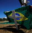 Ativista coloca bandeira do Brasil pintada com cruzes sobre cruz durante ato em homenagem a vítimas da Covid-19 em Brasília
14/07/2020
REUTERS/Adriano Machado  Foto: Reuters