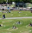 Em Düsseldorf, círculos marcados no gramado de um parque ajudam a manter o distanciamento entre as pessoas.   Foto: DW / Deutsche Welle
