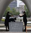 Lista com nomes de mortos na guerra é entregue ao prefeito de Hiroshima, Kazumi Matsui, por representante das famílias das vítimas da bomba atômica, no Parque da Paz
Kyodo/via REUTERS  Foto: Reuters