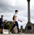 People wearing protective face masks walks through Trafalgar Square  Foto: Reuters / BBC News Brasil
