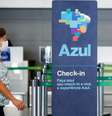 Passageira usando máscara de proteção passa pela frente de guichê da companhia aérea Azul. 11/3/2020. REUTERS/Adriano Machado  Foto: Reuters
