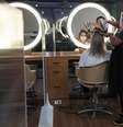 A hairdresser wearing protective mask and face shield uses a hair dryer on a customer's hair between acrylic walls set up for social distancing at a hair salon, as the city eases the restrictions imposed to control the spread of the coronavirus disease (COVID-19), in Sao Paulo, Brazil July 6, 2020. REUTERS/Amanda Perobelli  Foto: Reuters
