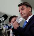 O presidente do Brasil, Jair Bolsonaro, tira a máscara antes de falar à mídia sobre a ajuda financeira emergencial do governo federal durante a crise do coronavírus (COVID-19) no Palácio do Planalto, em Brasília  Foto: Ueslei Marcelino / Reuters