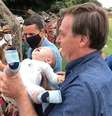 Jair Bolsonaro pega bebê nos braços durante viagem a Goianópolis; presidente voltou a dispensar o uso da máscara em compromisso público.  Foto: Reprodução/ Instagram/ Major Vítor Hugo / Estadão