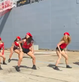 O grupo dançando twerk em frente ao novo navio de guerra australiano HMAS Supply  Foto: @alexbrucesmith/Twitter / BBC News Brasil