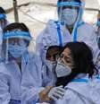 Grupo de trabalhadoras da saúde com equipamento de proteção individual se abraça  Foto: Reuters / BBC News Brasil
