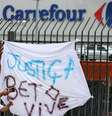 Homem tira foto próximo a cartaz pedindo justiça pela morte de um homem espacado e morto numa loja do Carrefour, em Porto Alegre. 20/11/2020. REUTERS/Diego Vara  Foto: Reuters