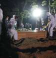 Coveiros com trajes de proteção fazem o sepultamento noturno no cemitério de Vila Formosa, em São Paulo  Foto: Amanda Perobelli / Reuters