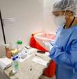 Profissional da saúde analisa testes de covid-19 em aeroporto brasileiro  Foto: Cristine Rochol/Ulan/Pool/Latin America News Agency  / Reuters
