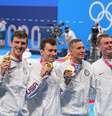 Equipe do revezamento dos Estados Unidos exibe a medalha de ouro no pódio  Foto: Michael Kappeler/DPA/Reuters