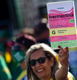 Mulher em manifestação pró-Bolsonaro segura cartaz com desenho de caixa de ivermectina  Foto: Getty Images / BBC News Brasil