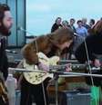 Banda The Beatles se apresenta em topo de prédio no Apple Rooftop Concert, em 1969  Foto: Reprodução de cena de 'Rooftop Performance | The Beatles: Get Back' / Disney + / Estadão