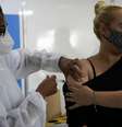 Mulher toma vacina contra covid-19  Foto: REUTERS/Ricardo Moraes